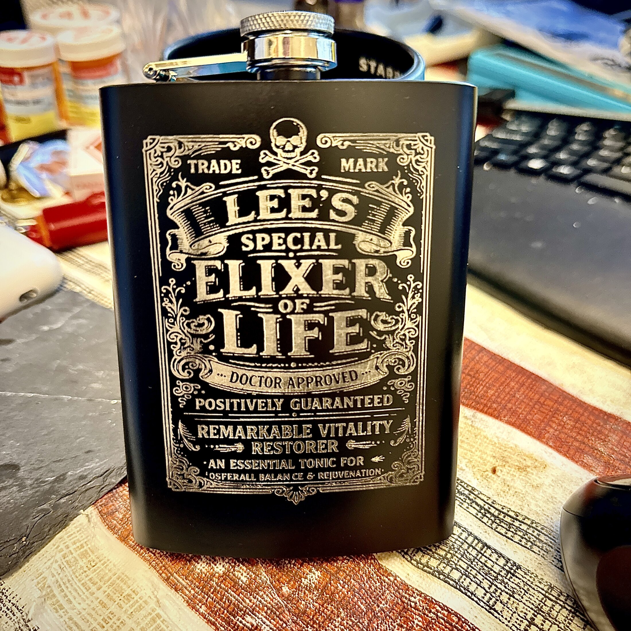 Laser engraved black flask with detailed elixir label